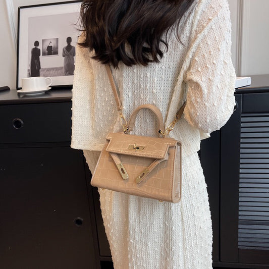 beige buckle crossbody bag, beige crossbody bag with an adjustable strap, buckle crossbody bag, crossbody bag with an adjustable strap