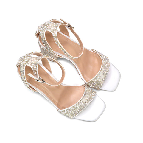 A pair of women's heeled sandals with glittery silver straps, white square toes, and low block heels, shown on a plain white background.